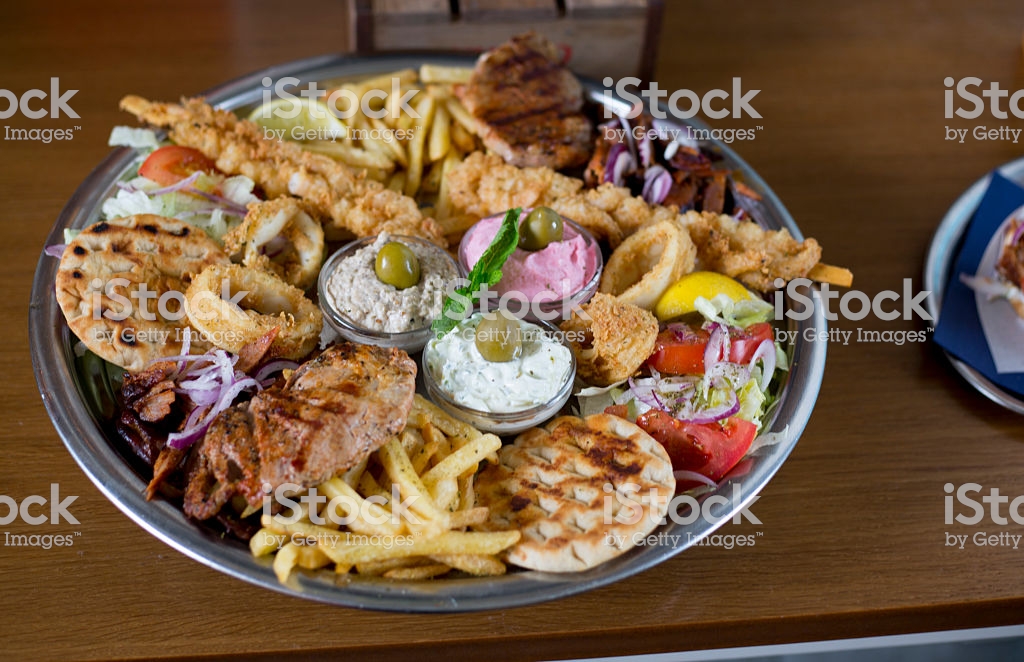 Huge Food plate with salad, French Fries and sauces.
